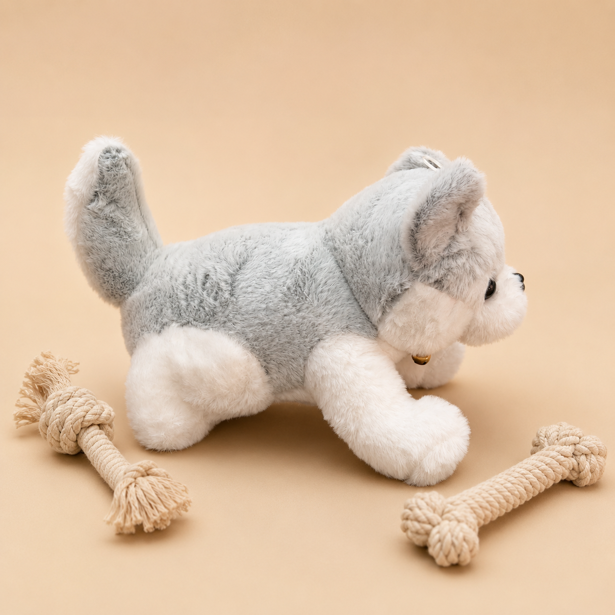 Plush dog toy with a rope toy on a beige background