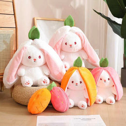 Set of plush toys shaped like bunnies and carrots on a wooden floor.